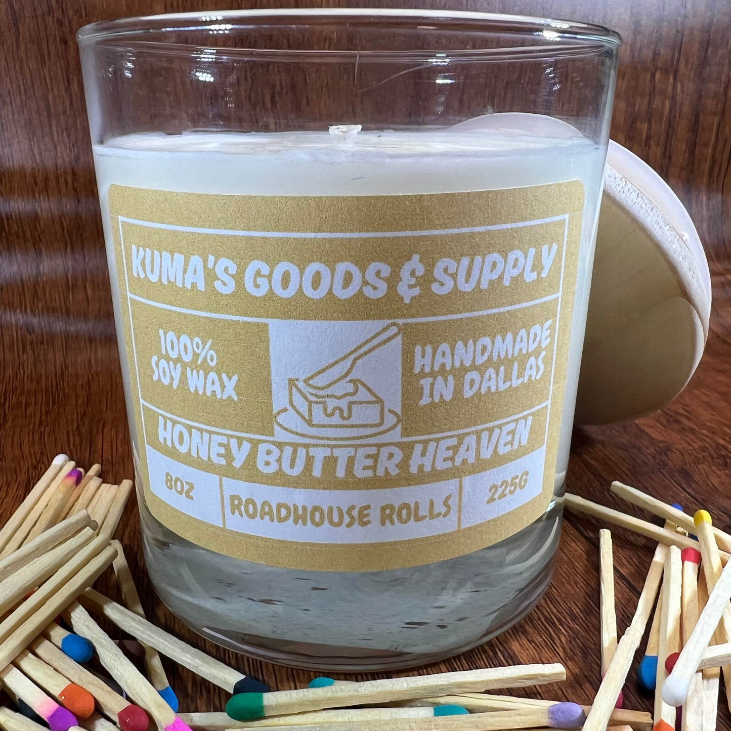 Candle with a label on a wooden surface with matches around