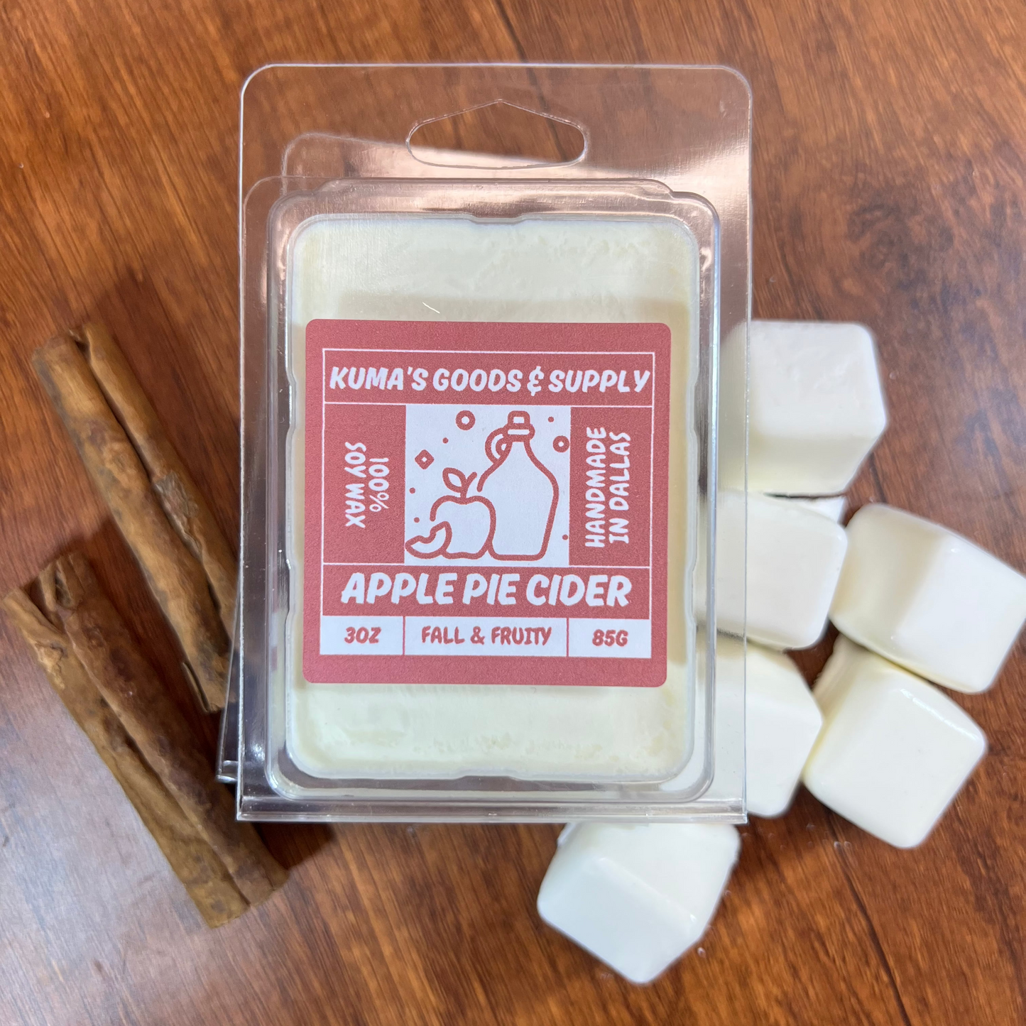 Packaged apple pie cider wax melt on a wooden surface with cinnamon sticks.