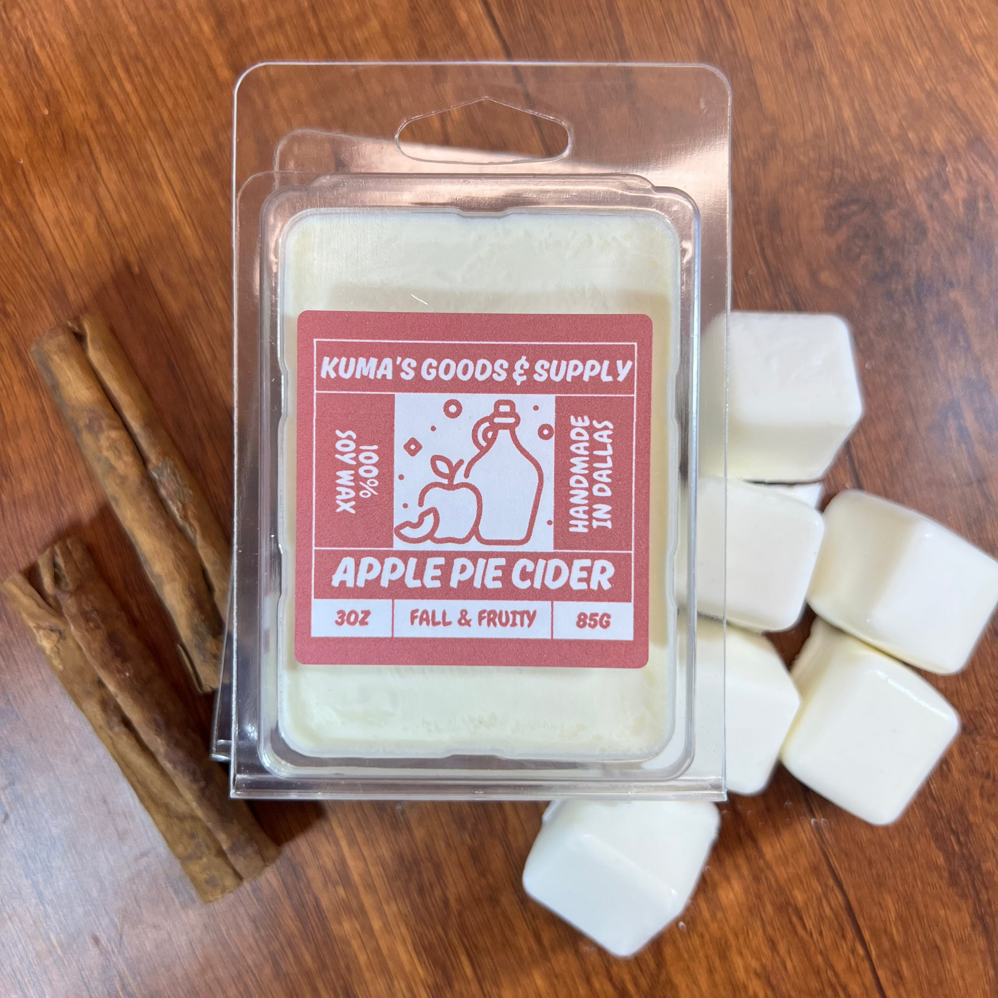 Packaged apple pie cider wax melt on a wooden surface with cinnamon sticks.