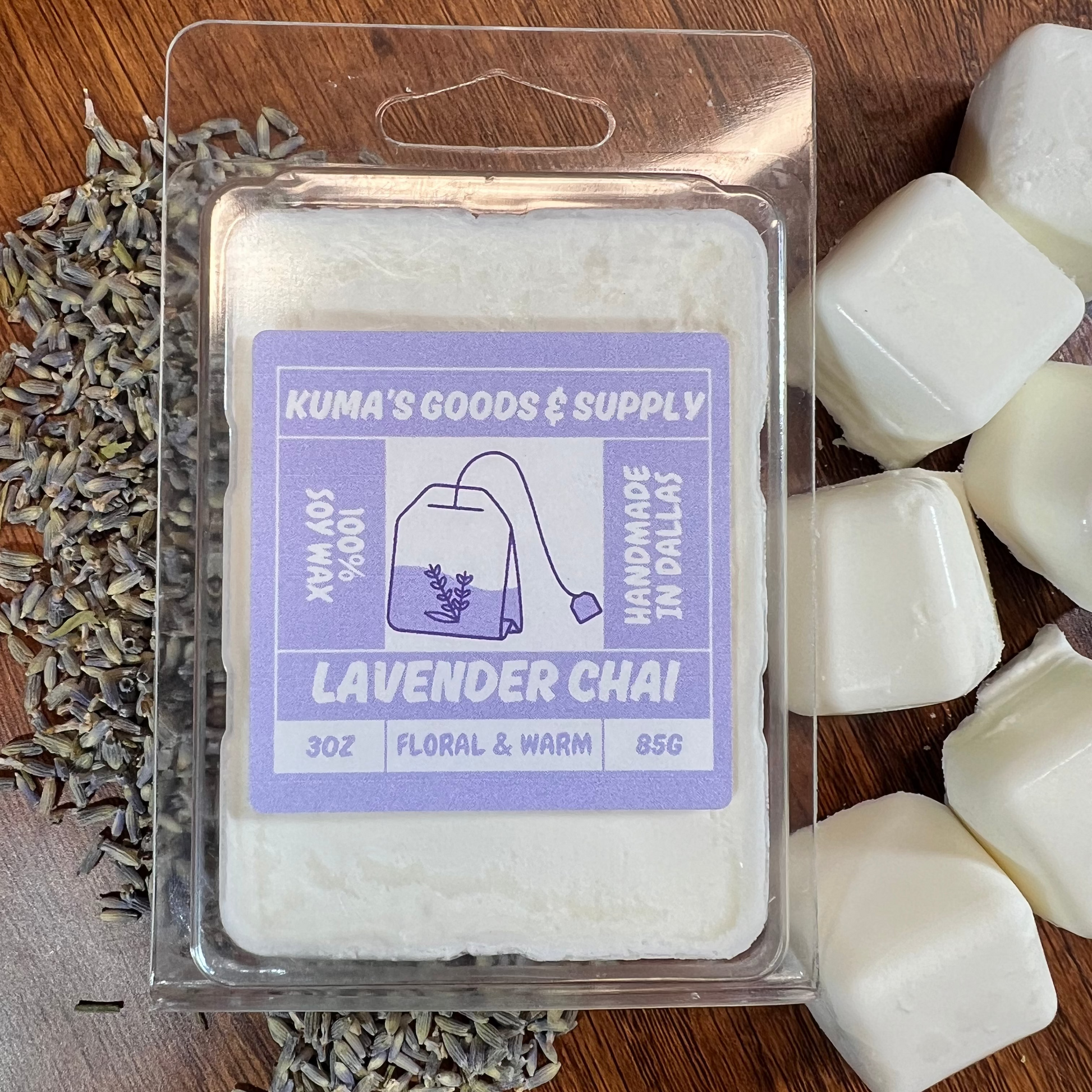 Kuma's Goods & Supply lavender chai product packaging on a wooden surface with lavender buds.